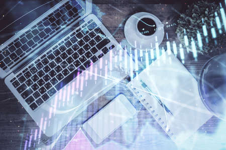 Financial market graph and top view computer on the desktop background. Double exposure. Investment...