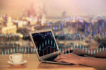 Double exposure of businesswoman hands typing on computer and forex chart hologram drawing....
