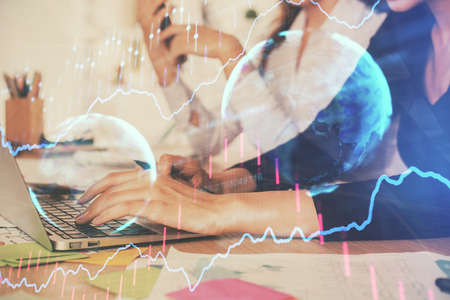 Multi exposure of woman hands typing on computer and financial graph hologram drawing. Stock market...
