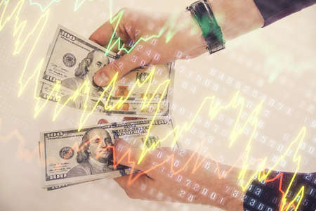Multi exposure of financial graph drawing hologram and USA dollars bills and man hands. Analysis...