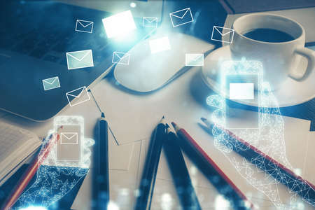 Desktop computer background in office and flying envelops hologram drawing. Double exposure. Electronic mail concept.の写真素材