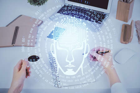 Double exposure of woman's writing hand on background with brain hud. Concept of learning.の写真素材