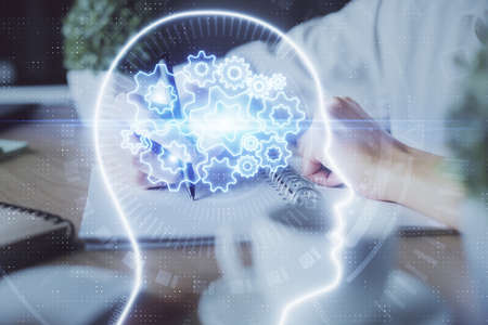 Multi exposure of writing hand on background with brain hologram. Concept of self learning.の写真素材