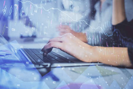 Multi exposure of woman hands typing on computer and financial graph hologram drawing. Stock market analysis concept.の写真素材