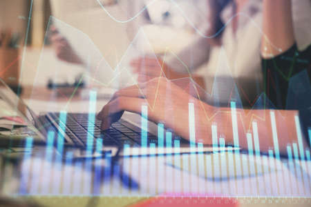 Multi exposure of woman hands typing on computer and financial graph hologram drawing. Stock market...