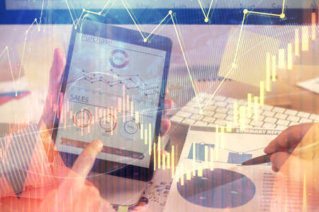 Multi exposure of man's hands holding and using a phone and financial chart drawing. Market analysis...