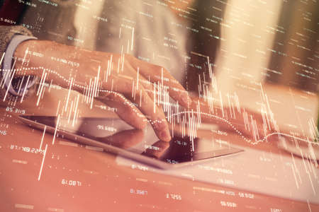 Double exposure of forex graph drawing and man and woman working together holding and using a mobile...