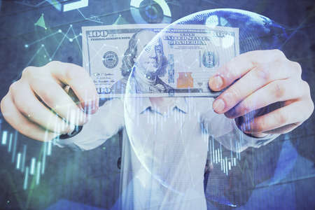 Multi exposure of financial graph drawing hologram and USA dollars bills and man hands. Analysis...
