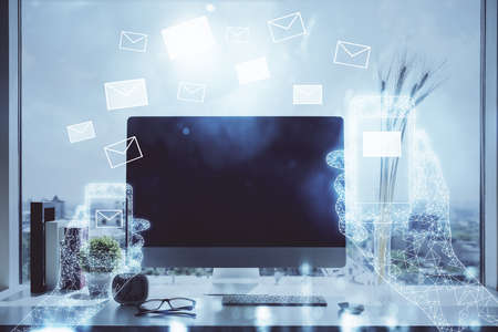 Desktop computer background in office and flying envelops hologram drawing. Double exposure....