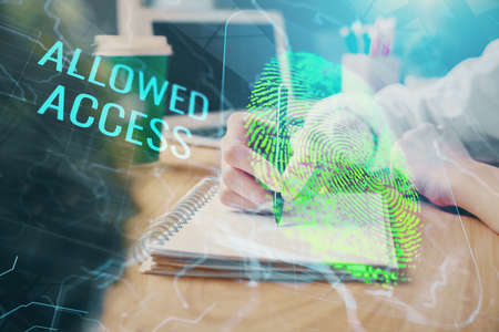 Blue fingerprint hologram over hands taking notes background. Concept of security. Double exposure