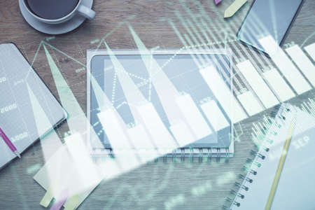 Double exposure of forex chart hologram over desktop with phone. Top view. Mobile trade platform...