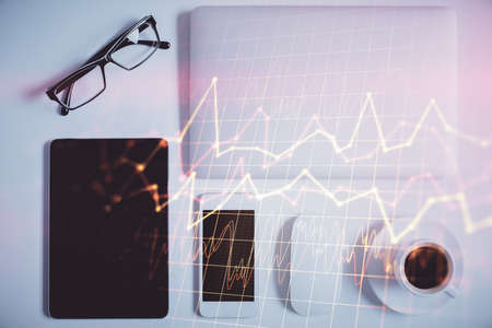Multi exposure of financial chart hologram over desktop with phone. Top view. Mobile trade platform...