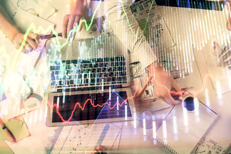 Double exposure of man and woman working together and financial graph hologram. Business concept....