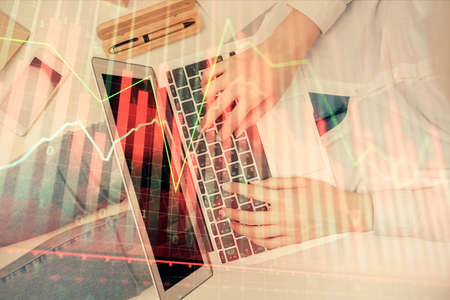 Double exposure of woman hands working on computer and forex graph hologram drawing. Top View....