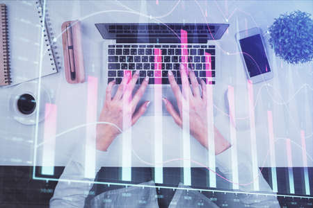 Double exposure of woman hands working on computer and forex chart hologram drawing. Top View. Financial analysis concept.の写真素材