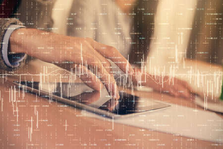 Double exposure of forex graph drawing and man and woman working together holding and using a mobile...