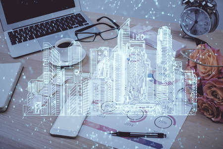 Desktop computer background in office and big town buildings hologram drawing. Double exposure. Smart city concept.の写真素材