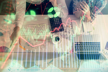 Double exposure of man and woman working together and financial chart hologram drawing. market...