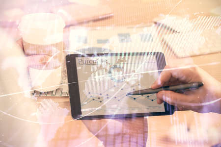 Double exposure of man's hands holding and using a phone and financial chart drawing. Market...