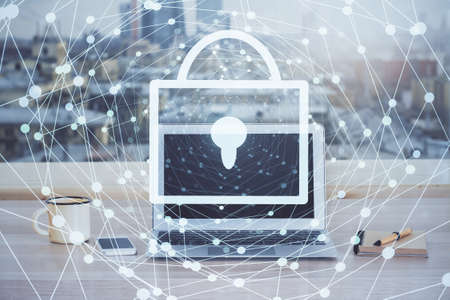 Double exposure of desktop with computer and lock icon hologram. Concept of data safety.