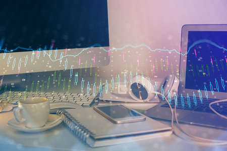 Financial graph colorful drawing and table with computer on background. Double exposure. Concept of international markets.の写真素材