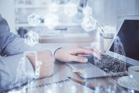 Technology theme hologram with man working on computer on background. High tech concept. Double exposure.の写真素材