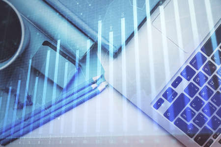 Double exposure of forex graph drawing over desktop background with computer. Concept of financial...