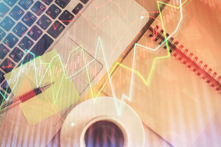 Stock market graph and top view computer on the table background. Double exposure. Concept of financial education.の写真素材