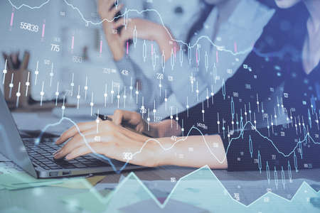 Multi exposure of woman hands typing on computer and financial graph hologram drawing. Stock market analysis concept.の写真素材