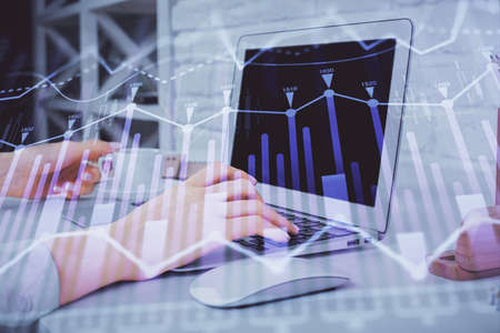 Double exposure of woman hands typing on computer and forex chart hologram drawing. Stock market...