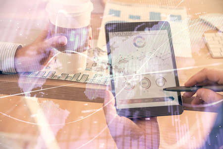 Double exposure of man's hands holding and using a phone and financial chart drawing. Market...