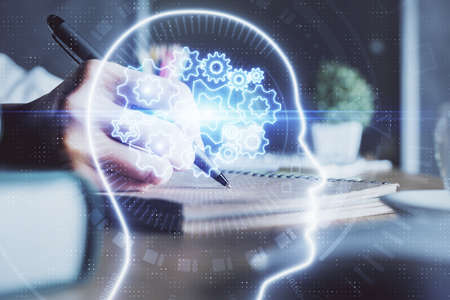 Multi exposure of writing hand on background with brain hologram. Concept of self learning.