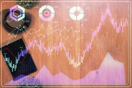 Multi exposure of financial chart hologram over desktop with phone. Top view. Mobile trade platform...
