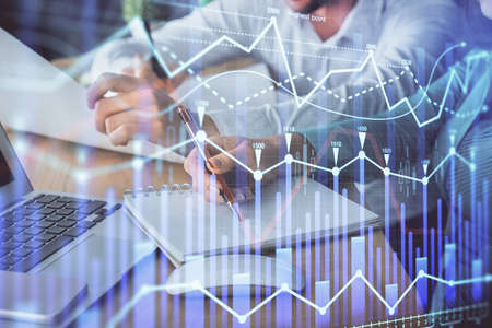 Double exposure of forex chart drawing over people taking notes background. Concept of financial...