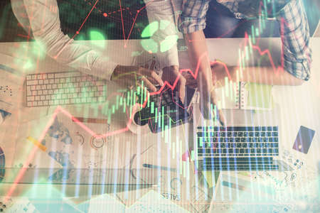 Double exposure of man and woman working together and financial graph hologram drawing. market...