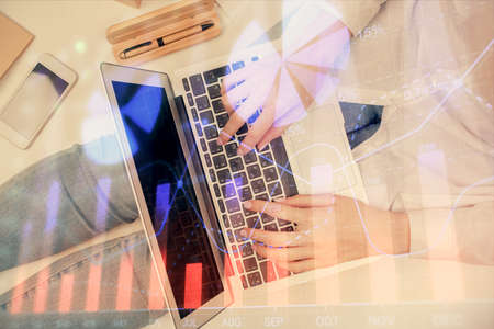 Double exposure of woman hands working on computer and forex graph hologram drawing. Top View. Financial analysis concept.の写真素材