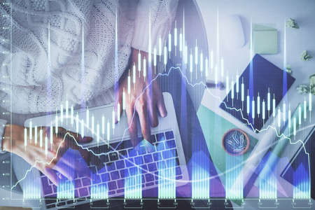 Multi exposure of woman hands working on computer and forex chart hologram drawing. Top View....