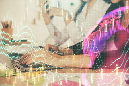 Multi exposure of woman hands typing on computer and financial graph hologram drawing. Stock market...