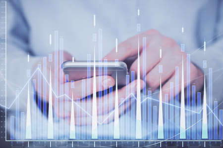 Double exposure of man's hands holding and using a digital device and forex graph drawing. Financial market concept.の写真素材