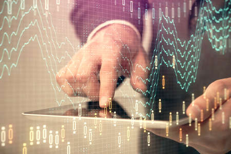 Multi exposure of man's hands holding and using a phone and financial chart drawing. Market analysis...
