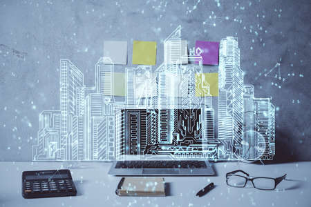 Desktop computer background in office and big town buildings hologram drawing. Double exposure. Smart city concept.の写真素材