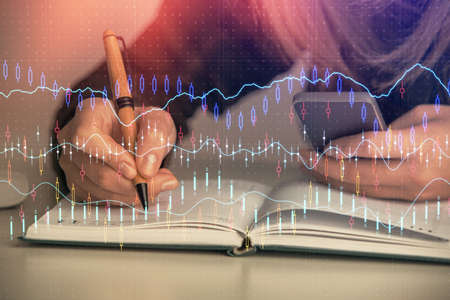Double exposure of businesswoman hands typing on computer and forex graph hologram drawing. Financial analysis concept.の写真素材