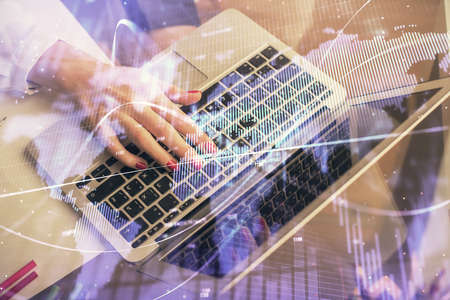 Double exposure of woman hands typing on computer and financial graph hologram drawing. Stock market...