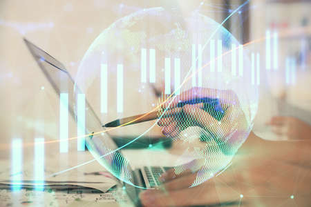 Multi exposure of woman hands typing on computer and financial graph hologram drawing. Stock market...