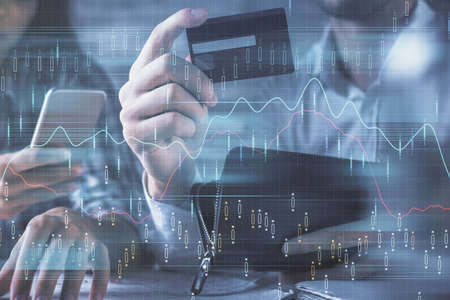 Double exposure of man and woman on-line shopping holding a credit card and forex graph hologram drawing. Stock market E-commerce pay on-line concept.の写真素材