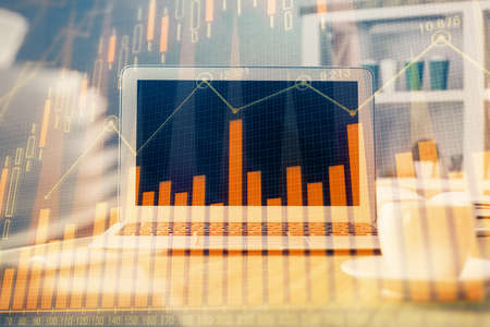 Financial chart drawing and table with computer on background. Double exposure. Concept of international markets.の写真素材