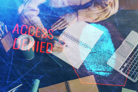Blue fingerprint hologram over hands taking notes background. Concept of security. Double exposureの写真素材