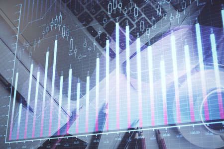 Double exposure of financial chart drawing over table background with computer. Concept of research...