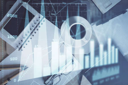 Double exposure of financial graph hologram over desktop with phone. Top view. Mobile trade platform...