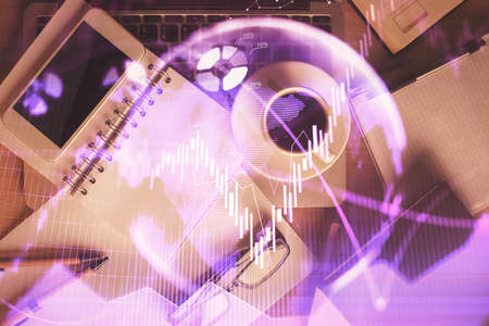 Double exposure of financial graph hologram over desktop with phone. Top view. Mobile trade platform...